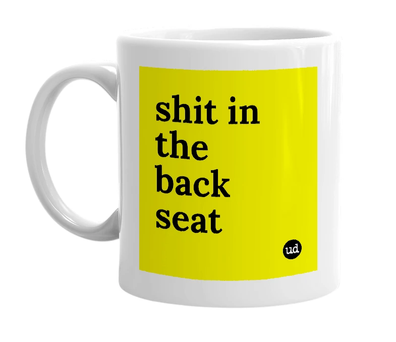 White mug with 'shit in the back seat' in bold black letters