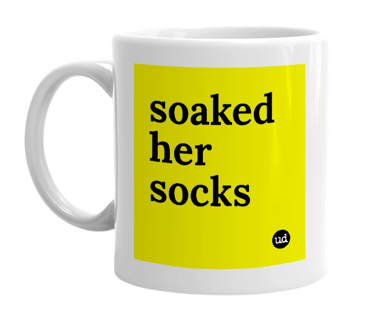 White mug with 'soaked her socks' in bold black letters