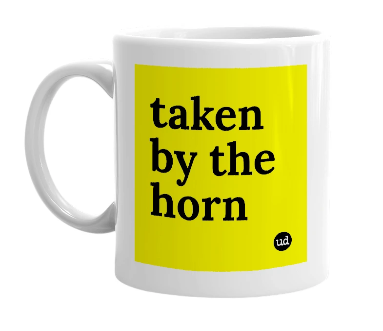 White mug with 'taken by the horn' in bold black letters