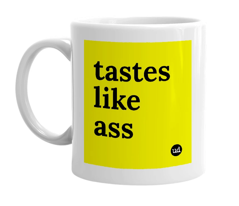 White mug with 'tastes like ass' in bold black letters