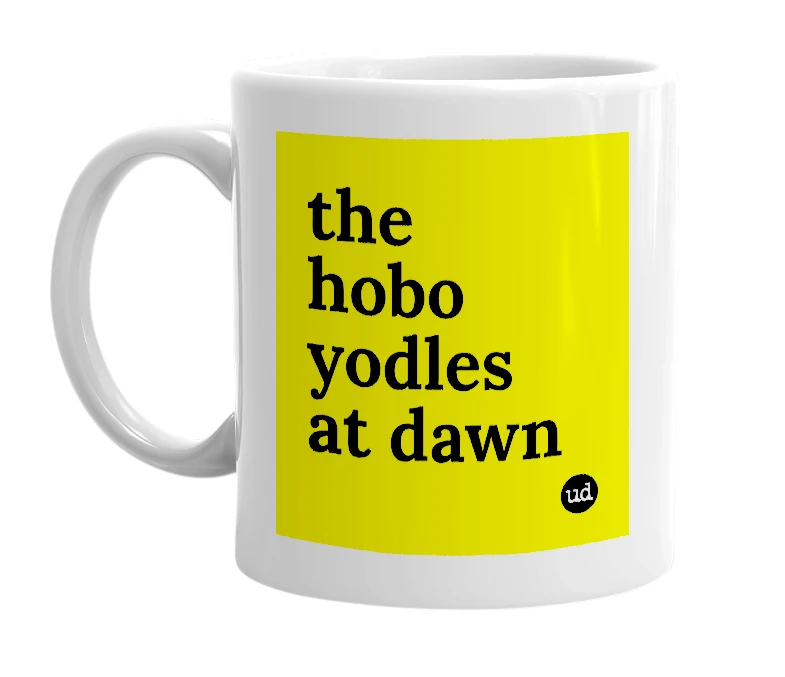 White mug with 'the hobo yodles at dawn' in bold black letters