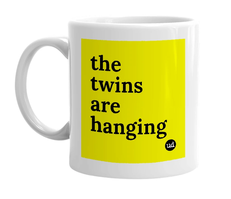 White mug with 'the twins are hanging' in bold black letters