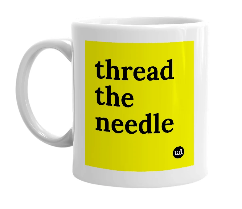 White mug with 'thread the needle' in bold black letters