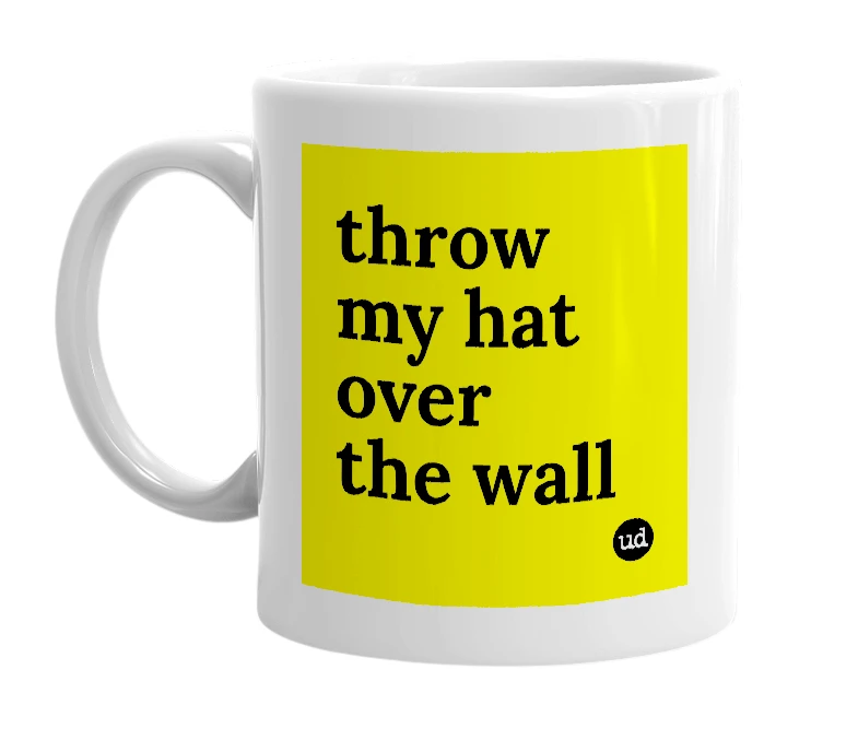 White mug with 'throw my hat over the wall' in bold black letters