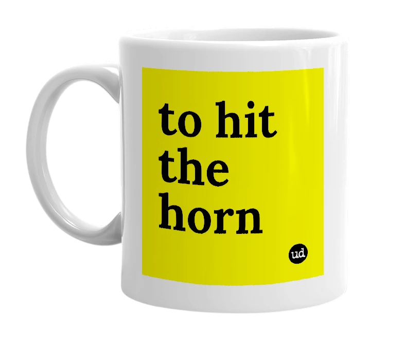 White mug with 'to hit the horn' in bold black letters