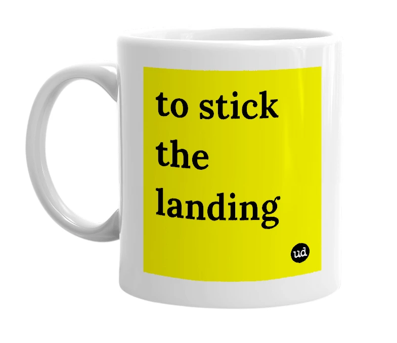 White mug with 'to stick the landing' in bold black letters