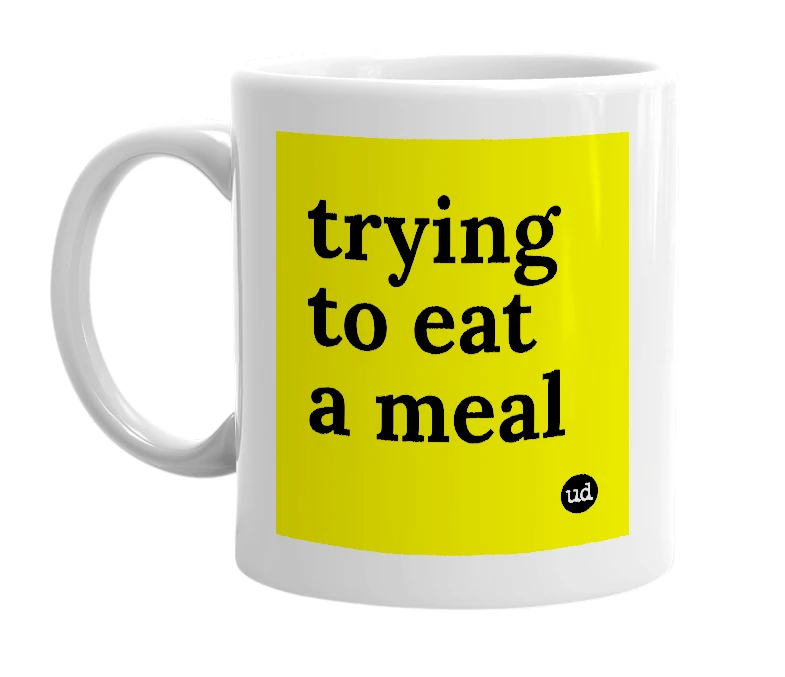 White mug with 'trying to eat a meal' in bold black letters