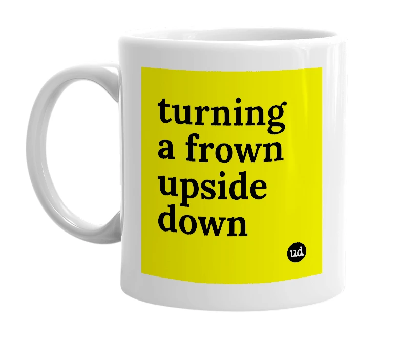 White mug with 'turning a frown upside down' in bold black letters