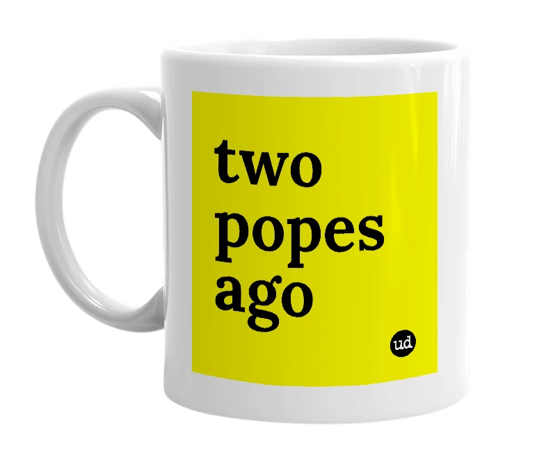 White mug with 'two popes ago' in bold black letters
