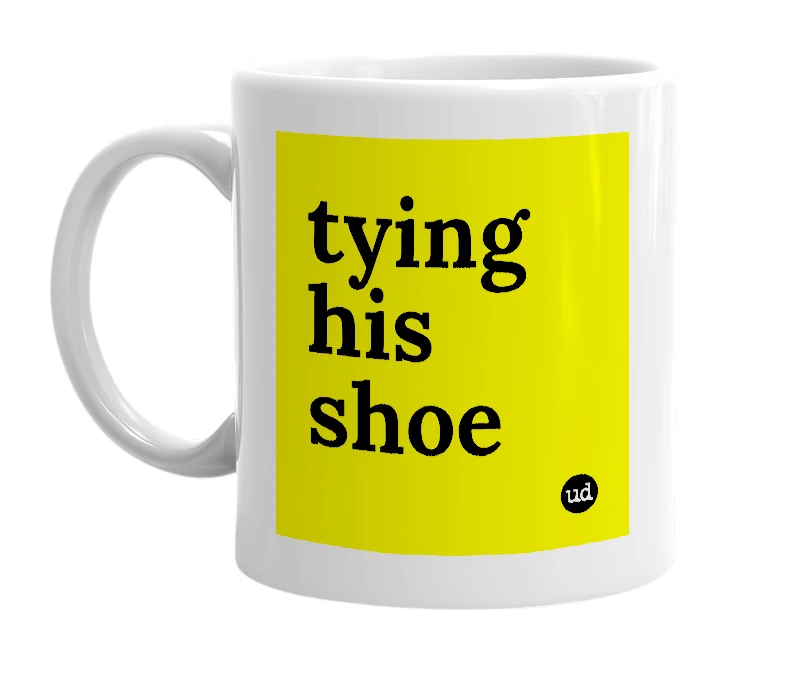 White mug with 'tying his shoe' in bold black letters