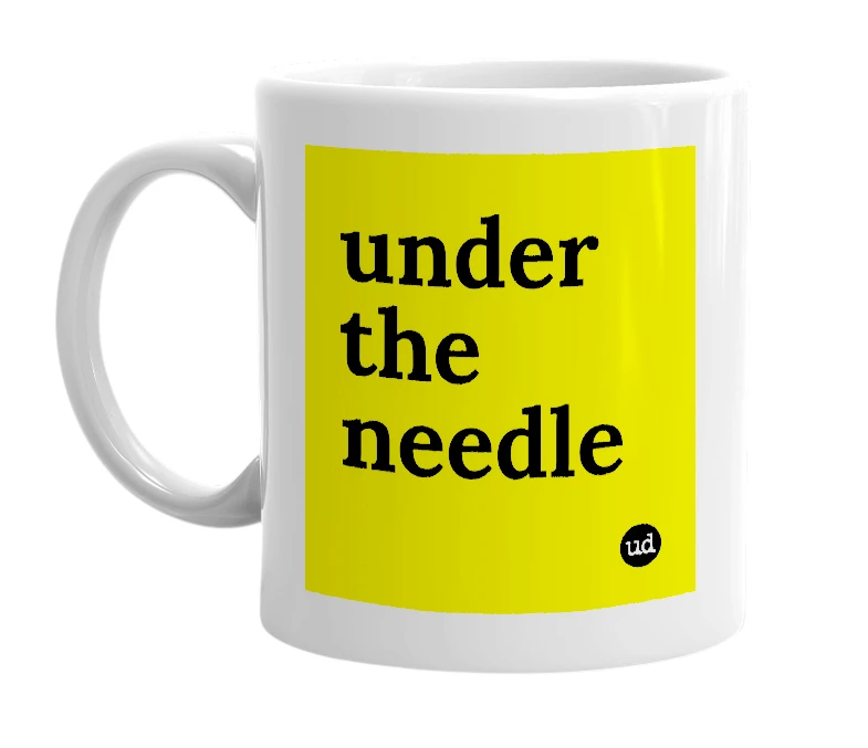 White mug with 'under the needle' in bold black letters