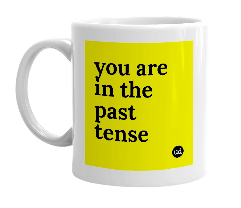 White mug with 'you are in the past tense' in bold black letters